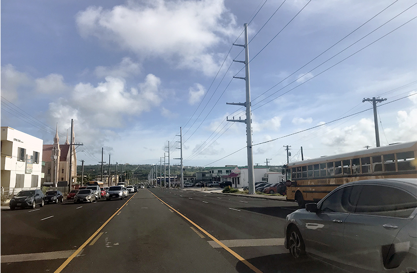 停車中のスクールバスと中央に黄色い車線がある道路